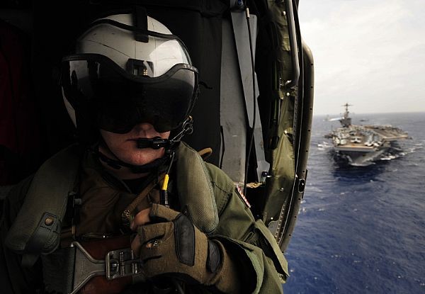 Một binh sỹ của Hải quân Mỹ đang quan sát tàu sân bay USS John C. Stennis từ cabin của một chiếc trực thăng MH-60S Sea Hawk. Đây là những trực thăng thuộc biên chế của phi đội bay trực thăng chiến đấu trên biển của hàng không mẫu hạm USS John C. Stennis (ảnh ngày 31/8/2011).